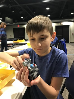 A young autistic boy shows off a lego creation he made as part of the Autism Society of Greater Akron's social clubs
