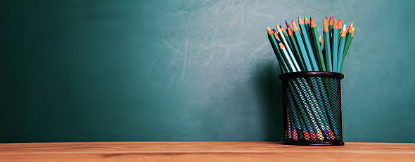 Cup of teal pencils against chalkboard