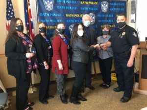 Group of police officers and volunteers wearing masks pose for a photo