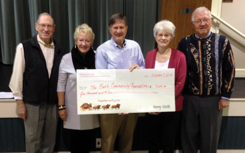 Group of people hold large check