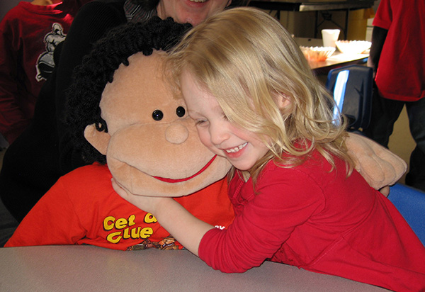 Young girl hugs stuffed puppet