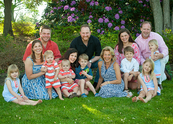 Buckey family pictured outside sitting in the grass in front of purple flowers