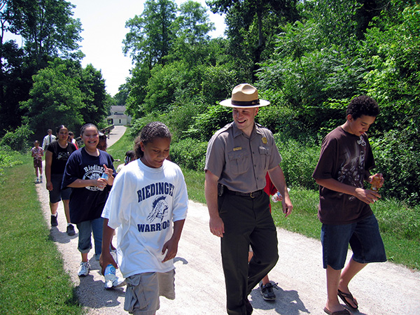 Park ranger walks with teens along trail