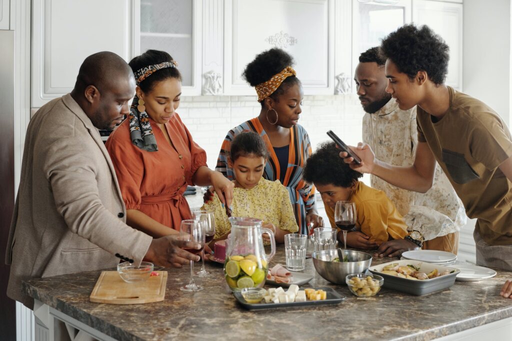 Black family gathers around kitchen