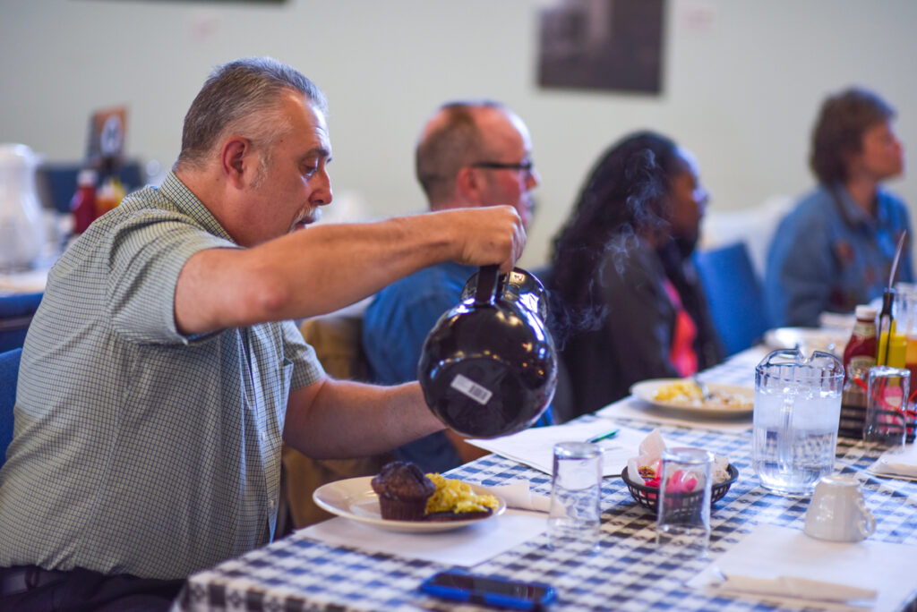 A man pours a cup of coffee at a South Street Ministries event