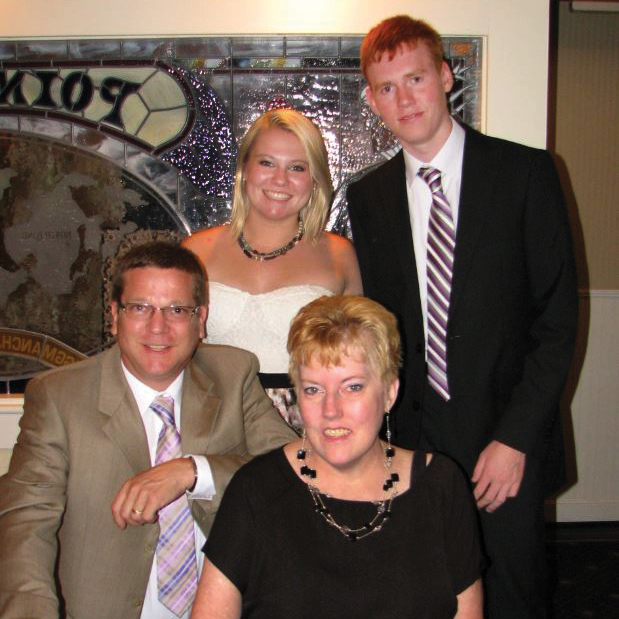 Parents and two kids pose for photo