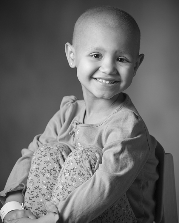 Young cancer patient poses in black and white portrait