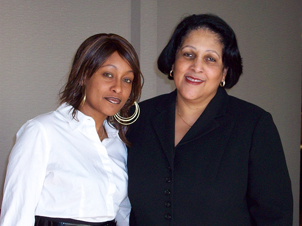 Two women standing next to each other and smiling