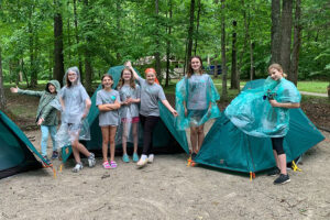 Girls standing outside camping tents