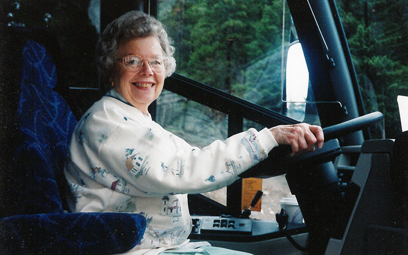 Woman smiling and driving bus