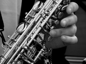 Black and white photo of a hand playing the saxophone