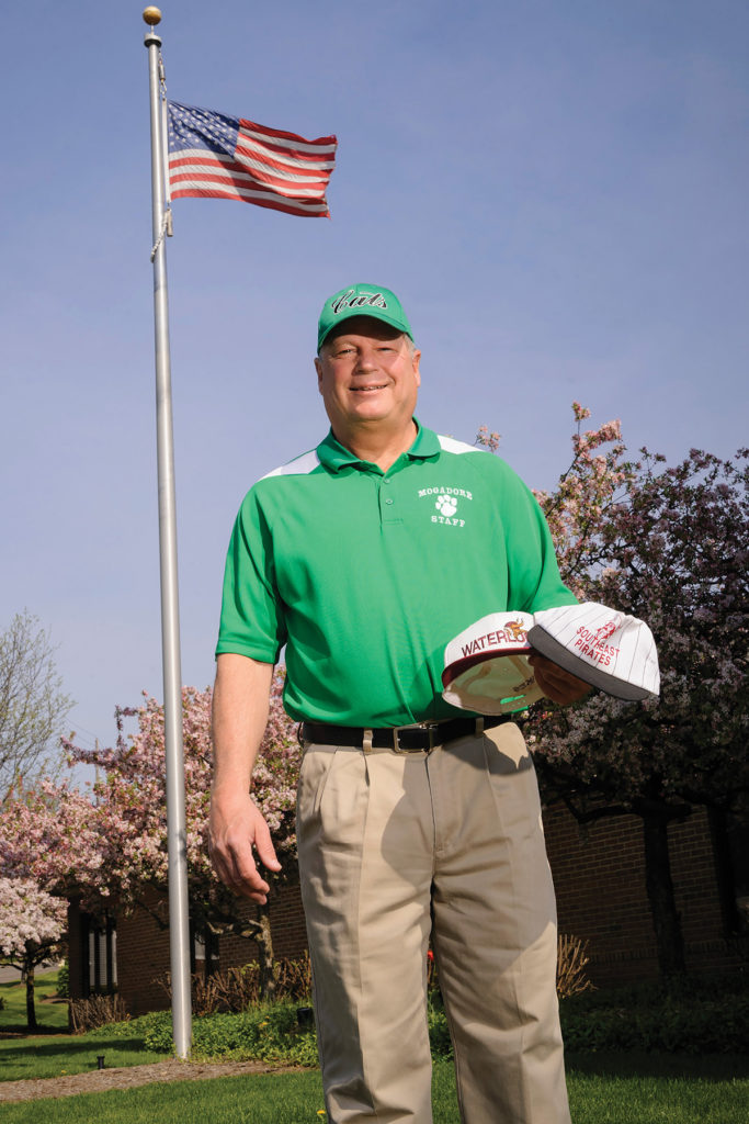 Man smiling with green cap and polo shirt