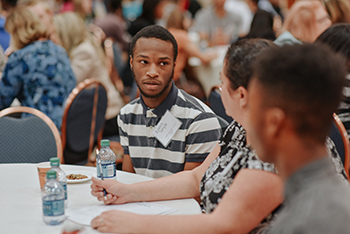 Young adults sitting at table talking