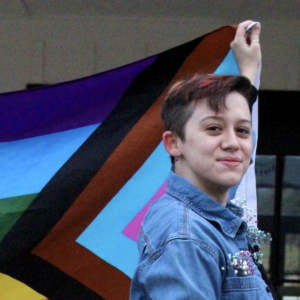 Sam Caley holding a pride flag.