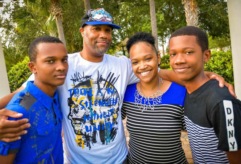 Black family with two sons smile for a photo
