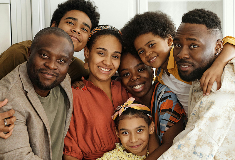 A group of Black family members hugging and smiling