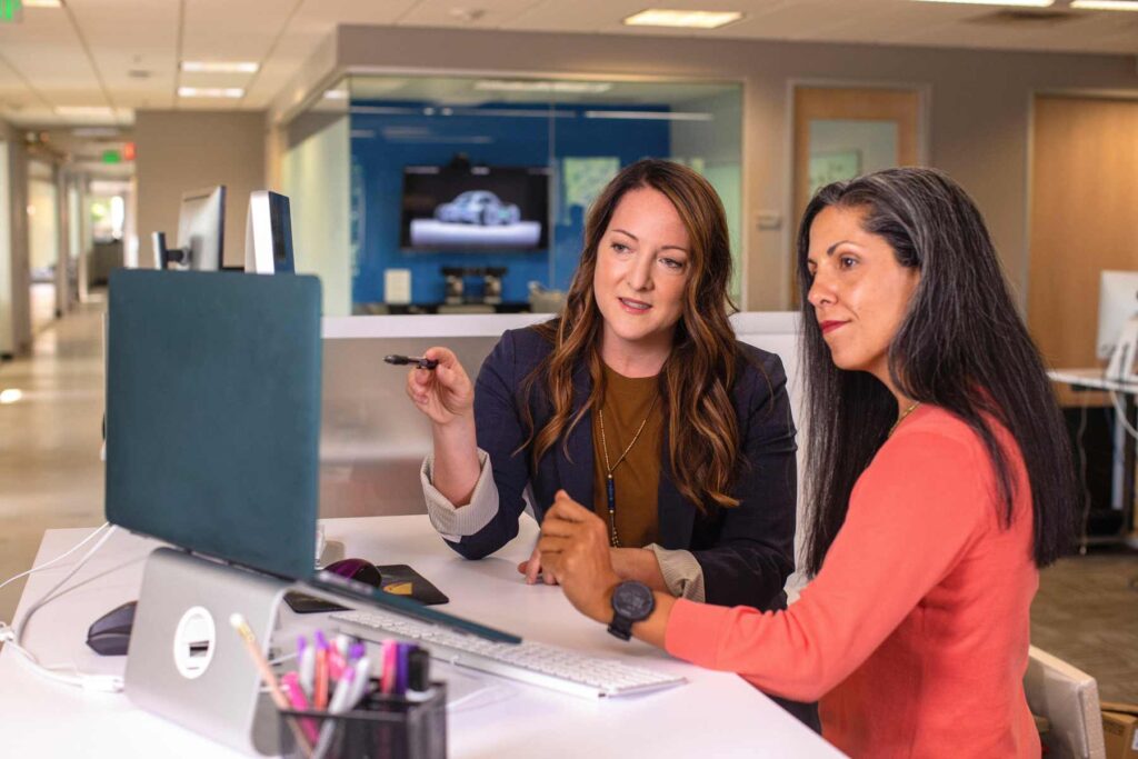 Two women looking at a computer in an office setting