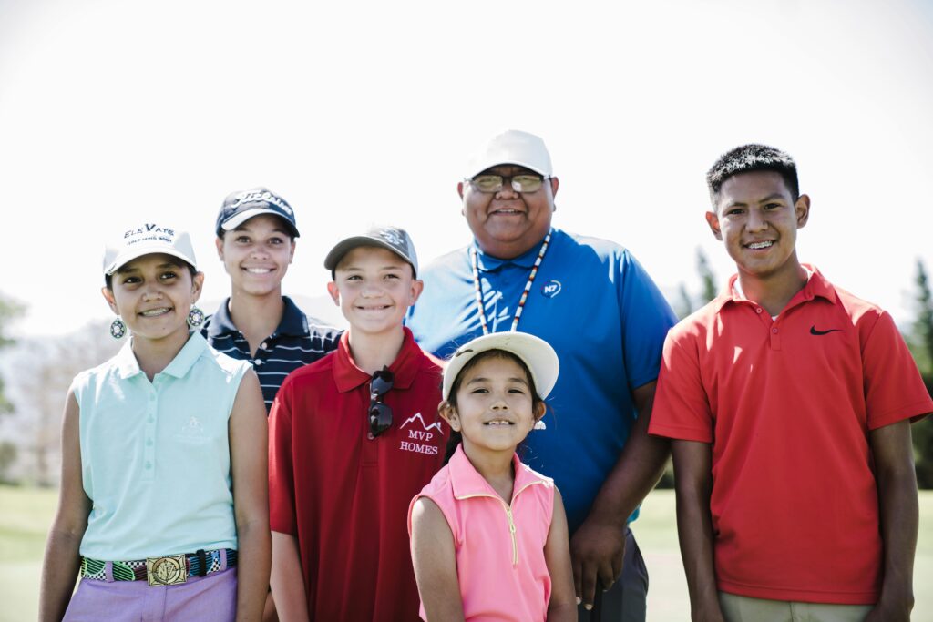 A group of six people, including children and adults are standing, posing for the camera.