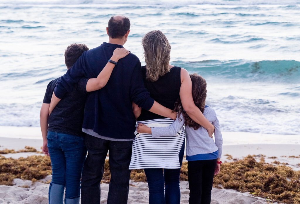 Family standing in front of the ocean