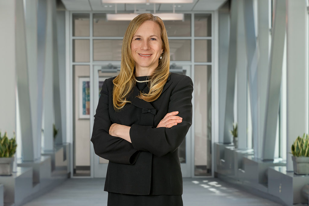 Woman standing and smiling with her arms crossed