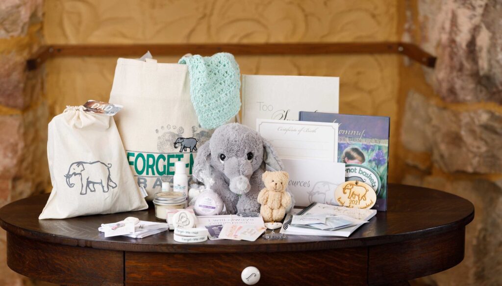 A basket of items like a stuffed elephant is displayed on a table.