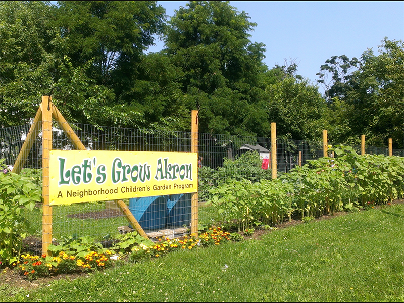 Community garden with a sign for Let's Grow Akron