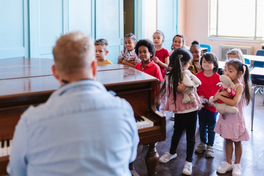 Teacher playing the piano to a group of preschoolers