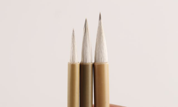 Three pencils with sharpened tips of varying length are lined up.