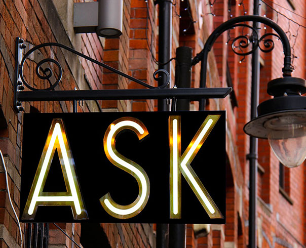 Outdoor building with a light-up sign that reads "ask"