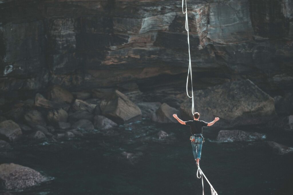 Person walking on tight rope across a cavern