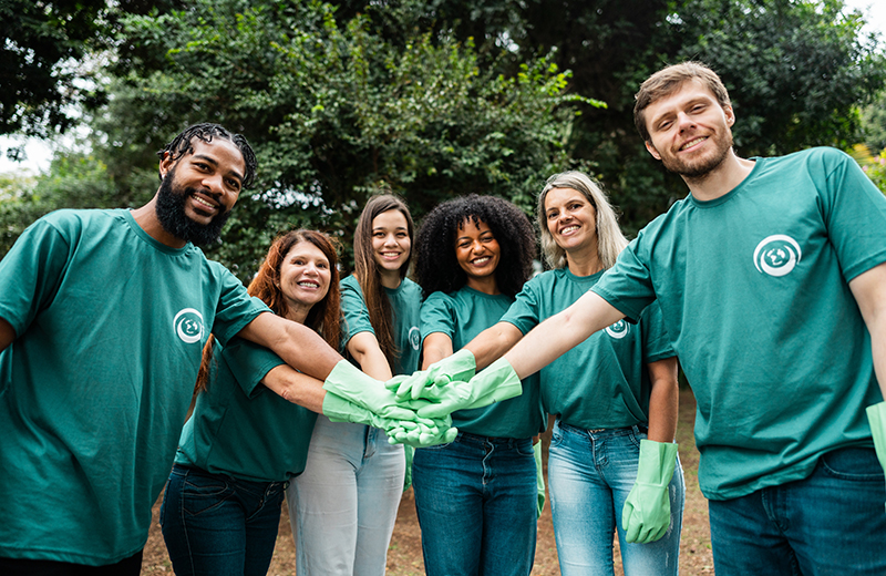 Group of volunteers putting hands together at a park